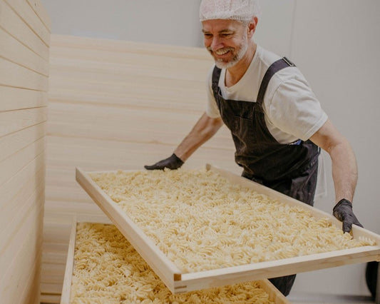 Duro Pasta founder Jesse Hegg stacking racks of dried pasta
